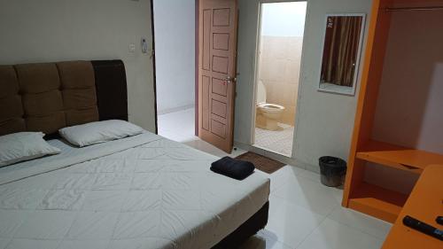 北干巴鲁IHomestay Pekanbaru的一间卧室配有一张床,浴室设有卫生间
