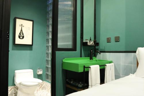 瓜拉丁加奴The Payang Hotel的一间带绿色水槽和卫生间的浴室