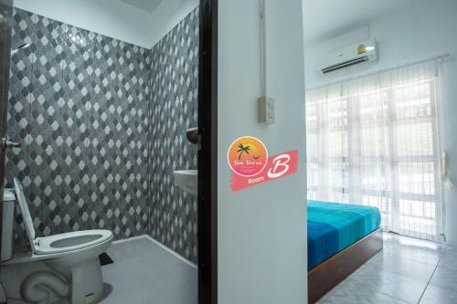 丽贝岛Tamtawan Guesthouse - ตามตะวันเกสเฮ้าส์的一间带卫生间的浴室和一张位于客房内的床。