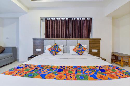 艾哈迈达巴德FabExpress Radhe Residency的一间卧室配有一张带五颜六色棉被的床