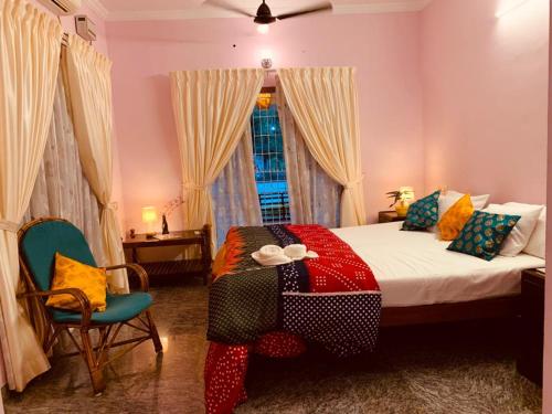瓦尔卡拉Surendram Villa的一间卧室配有一张带彩色毯子的床