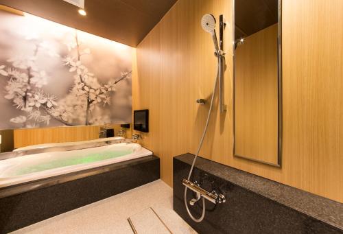GinanHOTEL SWEET SEASON-L的设有带浴缸和淋浴的浴室。