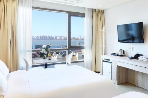 仁川市Hotel The Sea Star的酒店客房设有一张床和一个大窗户