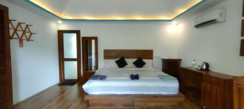 阿贡达The Coast Beach Resort的卧室配有带黑色枕头的白色床