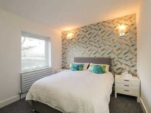 鲍内斯温德米尔BRANTLEA Detached 4 Bed Home, Hot Tub, Lake View, Parking, Pet Friendly的卧室设有一张白色大床和一扇窗户。
