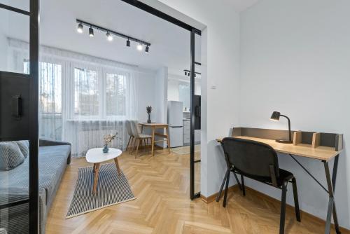 华沙RentPlanet - Apartament Syreny的客房设有一张床、一张桌子和一张桌子。