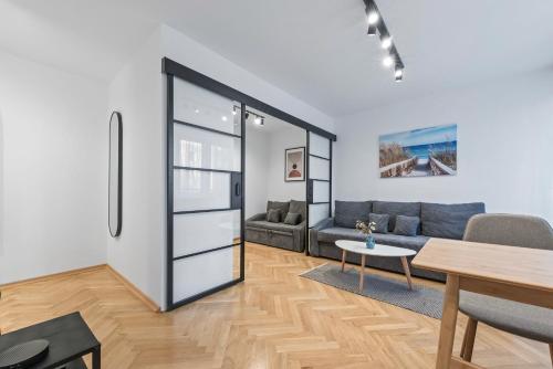 华沙RentPlanet - Apartament Syreny的客厅配有沙发和桌子