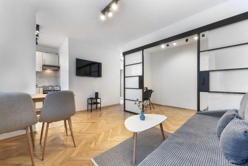 华沙RentPlanet - Apartament Syreny的客厅配有沙发和桌子