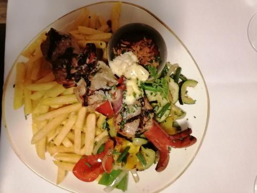 艾奇Appartement Alpenglück的盘子的食物,包括薯条、肉和蔬菜