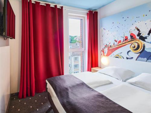 美因茨美因茨酒店-Hbf的一间卧室配有床和红色窗帘的窗户