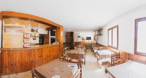 TuixenColl de Port的一间带桌椅的用餐室和一间酒吧