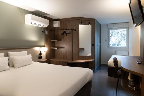 卢德南南锡 - 卢德斯基里亚德酒店的一间酒店客房,配有一张白色的床和一张书桌
