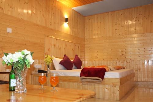 马拉里Guruchhaya hotel and cottages的木制客房内的一间卧室,配有一张床