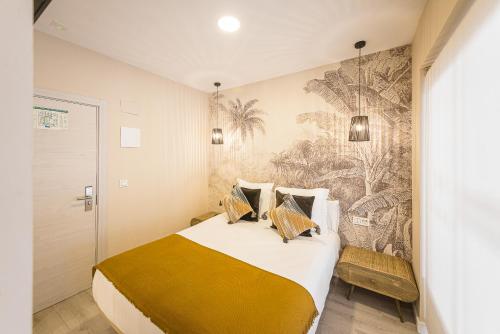 萨拉戈萨Hostal Plaza Boutique - Solo adultos的一间卧室配有一张大床和壁画