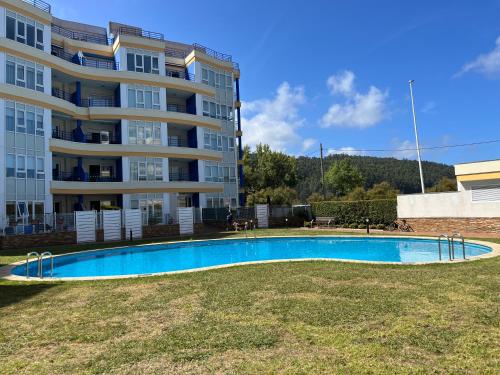 塞代拉Apartamento con vistas al mar Urb Puerto Azul B3的大楼前的游泳池