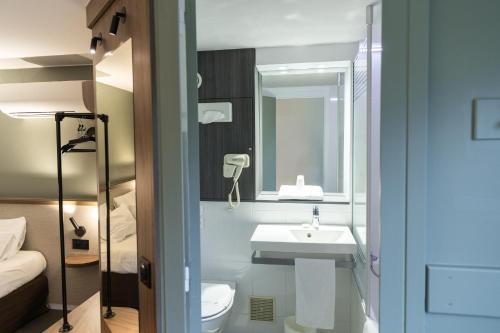 卢德南南锡 - 卢德斯基里亚德酒店的一间带水槽、卫生间和镜子的浴室
