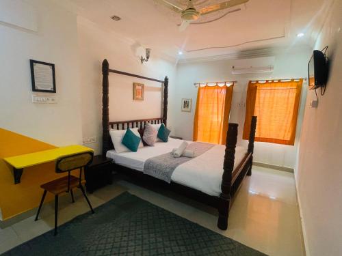 斋沙默尔Jaisalmer Hostel Crowd的一间卧室配有一张床和一张黄色的书桌