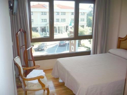 Bergondo博斯酒店的一间卧室设有一张床和一个大窗户