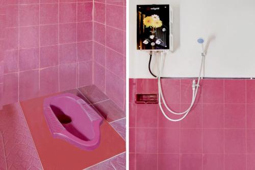 库宁岸OYO 90543 An-nur Guest House Syariah的粉红色的浴室设有淋浴和紫色厕所