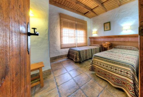 科尼尔-德拉弗龙特拉Hacienda los Majadales的一间卧室设有两张床和窗户。