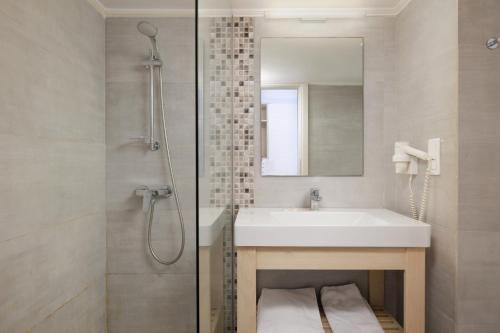达西亚Elea Beach Hotel的浴室配有盥洗盆和带镜子的淋浴
