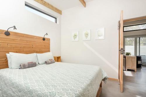 赫曼努斯Mountain and Sea Cottage的一间卧室配有一张大床和木制床头板