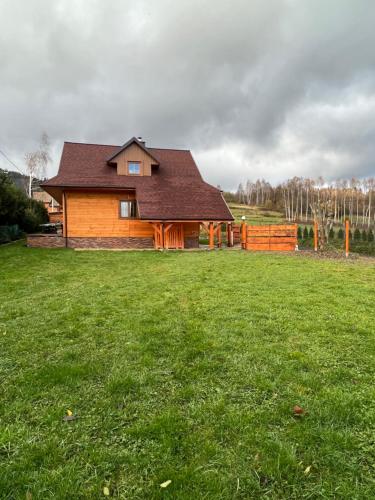 KamesznicaHighlander - drewniany dom w Beskidach的绿色庭院中的房屋