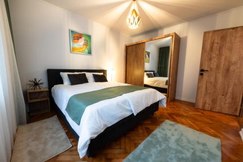 巴亚马雷Fortuna Apartments的一间卧室配有一张大床和镜子