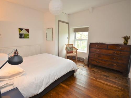 Ystrad-ffin3 Bed in Llandovery 76381的一间卧室配有一张床、梳妆台和椅子