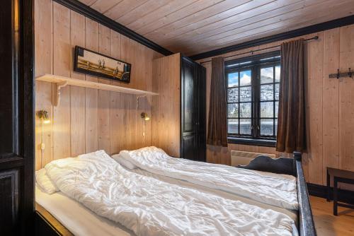 海姆瑟达尔Tinden Apartments的木墙客房内的一张大床