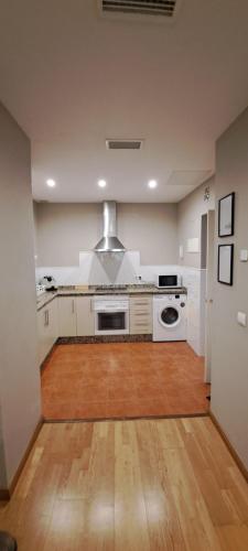 加的斯Apartamento Omnia, Feel Cádiz的铺有木地板的厨房配有白色家电