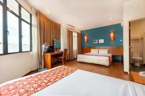 乔治市槟城维多利亚酒店的酒店客房设有两张床、一张书桌和窗户。