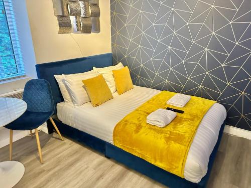 伯恩茅斯Serenity Retreat - Tranquil Apartment Close to Beach的一间卧室配有一张带黄色枕头和桌子的床