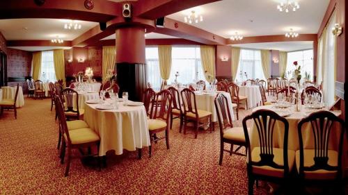 雅西印第安纳酒店的用餐室配有桌椅和白色桌布