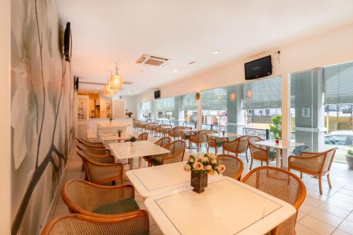 乔治市槟城维多利亚酒店的用餐室设有桌椅和窗户。
