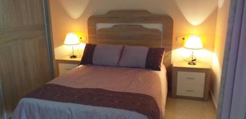 内尔哈Apartamento la Fragata Nerja的一间卧室配有一张带两盏灯的床。