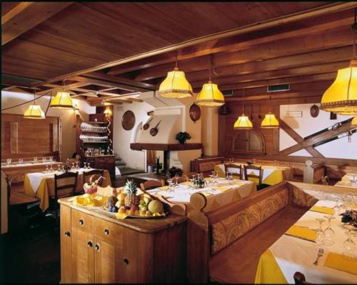 萨帕达RESIDENCE-RESORT BORGO AL SOLE的餐厅设有几张桌子和黄色的灯光