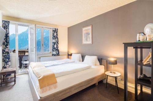 维尔德斯韦尔阿尔卑斯玫瑰酒店及花园的一间卧室设有一张大床和一个窗户。
