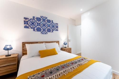 纳扎雷T2 Casa da Alegria的一间卧室配有蓝色和白色的床