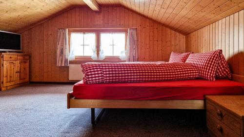 布鲁利绍尔Gasthaus Rössli的一间卧室配有一张带红色床单的床和一扇窗户。