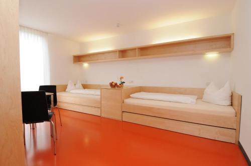多恩比恩Olympiazentrum Vorarlberg的一间卧室配有一张位于橙色地板的床