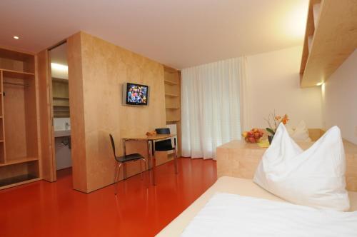 多恩比恩Olympiazentrum Vorarlberg的配有一张床和一张书桌的酒店客房