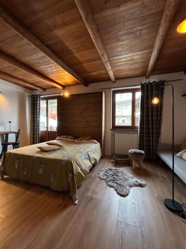 普拉吉拉托Locanda Allevè Hotel Ristorante的一间带一张床的卧室,位于带木制天花板的房间内
