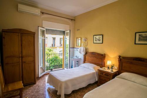 塞维利亚甜蜜的梦酒店的一间带两张床的卧室和一个阳台