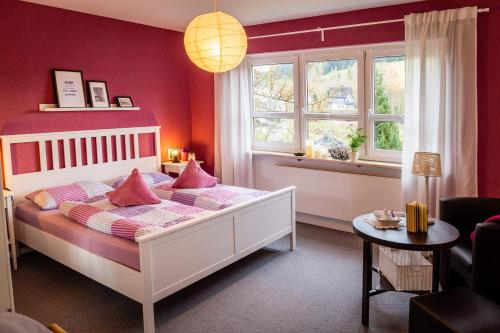 LudwigsstadtFerienwohnung Haus am Sommerberg的卧室配有白色床和粉红色枕头