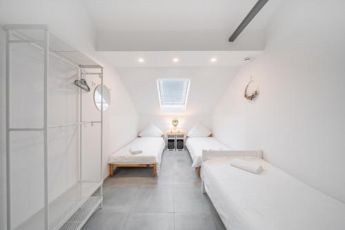 莱茵豪森La Piazza-Rheinhausen的白色的客房配有两张床和镜子