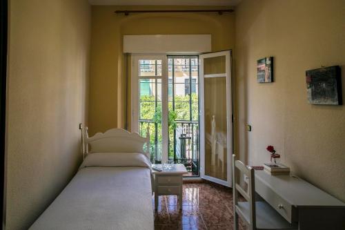 塞维利亚甜蜜的梦酒店的一间带两张床的卧室和通往阳台的门