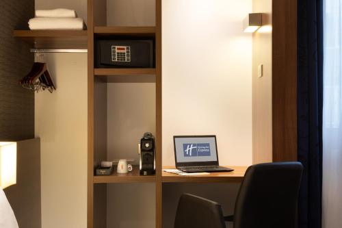 亚眠快捷假日阿米安酒店的客房设有一张桌子和一台笔记本电脑