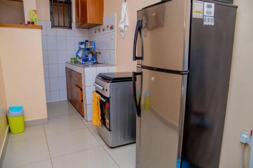 KisiiIT IS WELL HOMES的厨房配有不锈钢冰箱和炉灶。