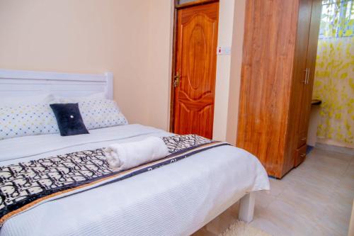 KisiiIT IS WELL HOMES的一间卧室配有一张床和一扇木门